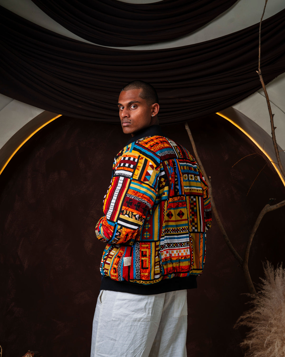 Back of the bomber worn print side out, showing the full spread of the African fabric panels
